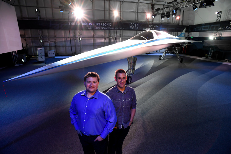 Blake Scholl, left, and Joe Wilding, right, both co-founders of Boom Technology, stand in front of a large model of the new XB-1 Supersonic Demonstrator at their their Hanger at Centennial Airport on November 14, 2016 in Centennial, Colorado. Boom Technology has been building a supersonic jet that can travel with 40 passengers from New York to London in 3.4 hours and charge "mainstream" fares.  The jet goes Mach 2.2 or 1451 mph and is slated for its first test flight in 2017. Helen H. Richardson, The Denver Post